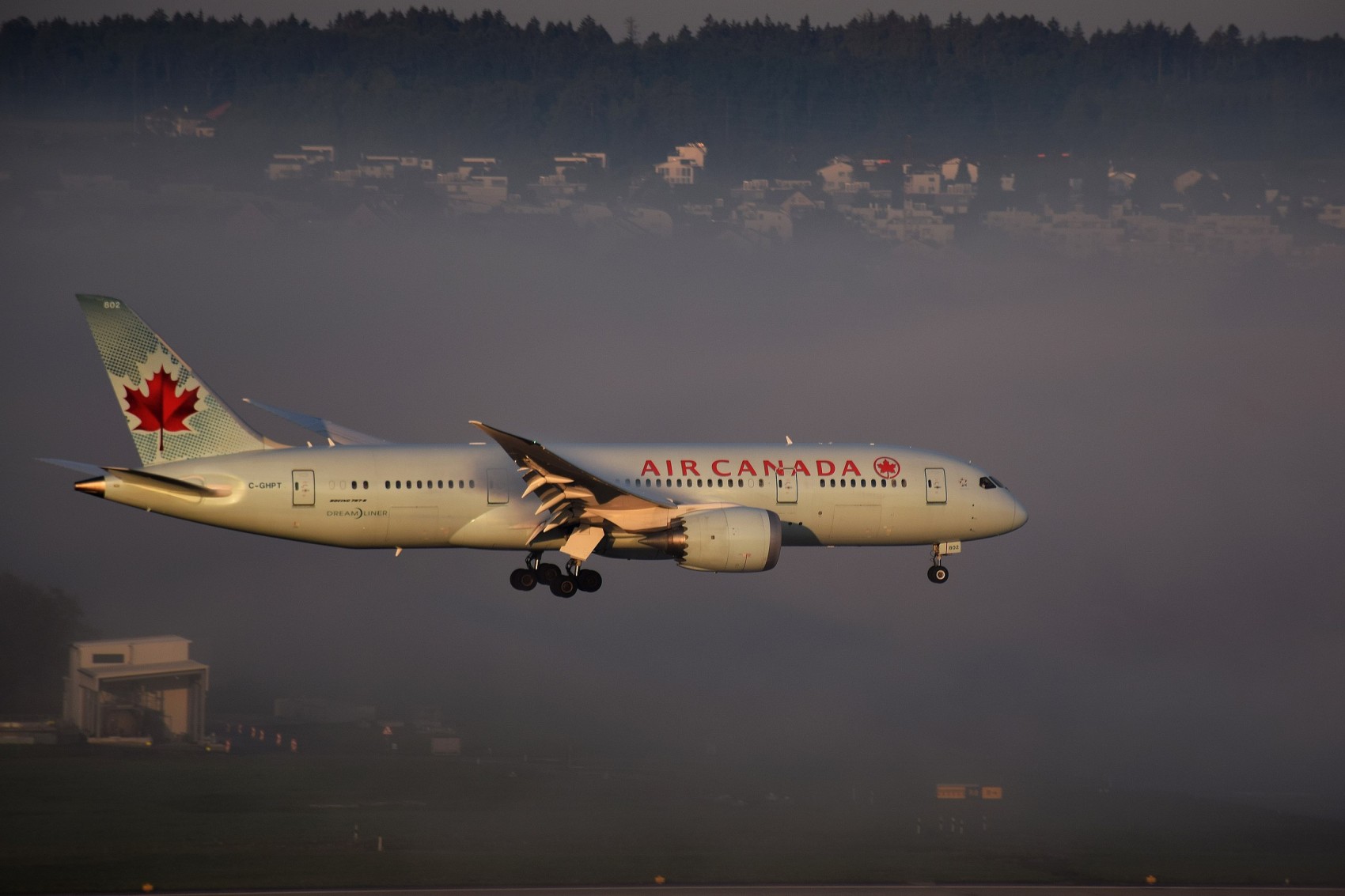 air canada plane landing in zurich airport with morning fog